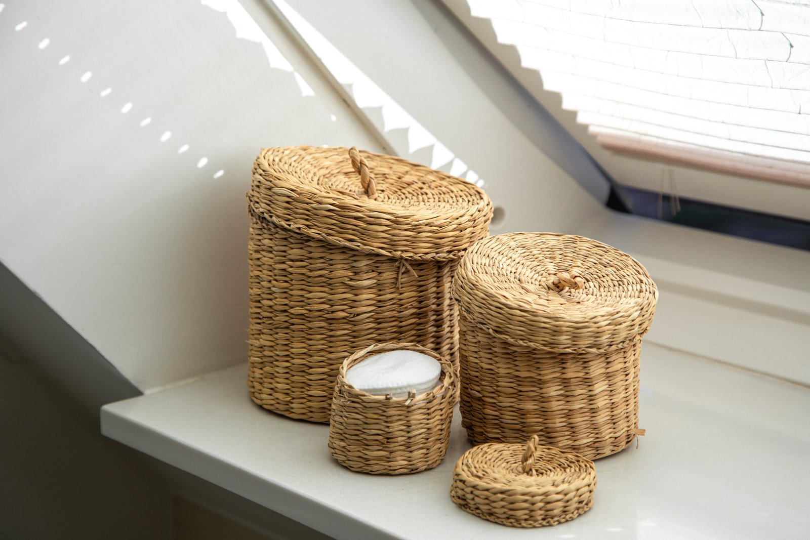 Three wicker boxes for cosmetics and personal hygiene items in the bathroom, boxes with natural materials, eco concept.